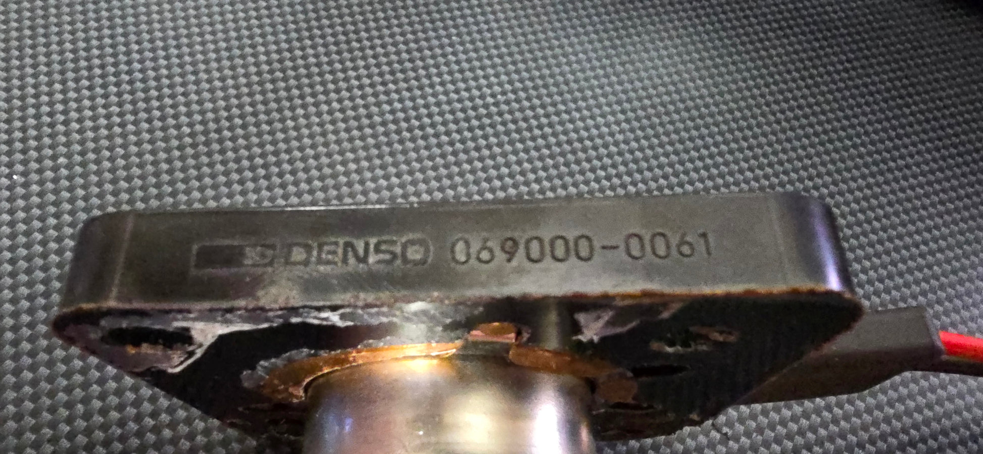 Denso component with visible model number on a textured surface